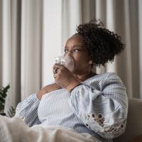 Mature woman using an inhalation mask at home