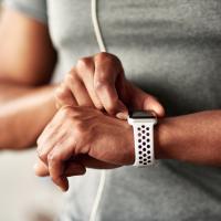 Fitness man taking a break, checking activity tracker