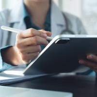 Image of a medical professional using a tablet and a stylus 